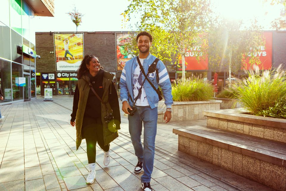 Stel wandelt lachend door Almere Centrum